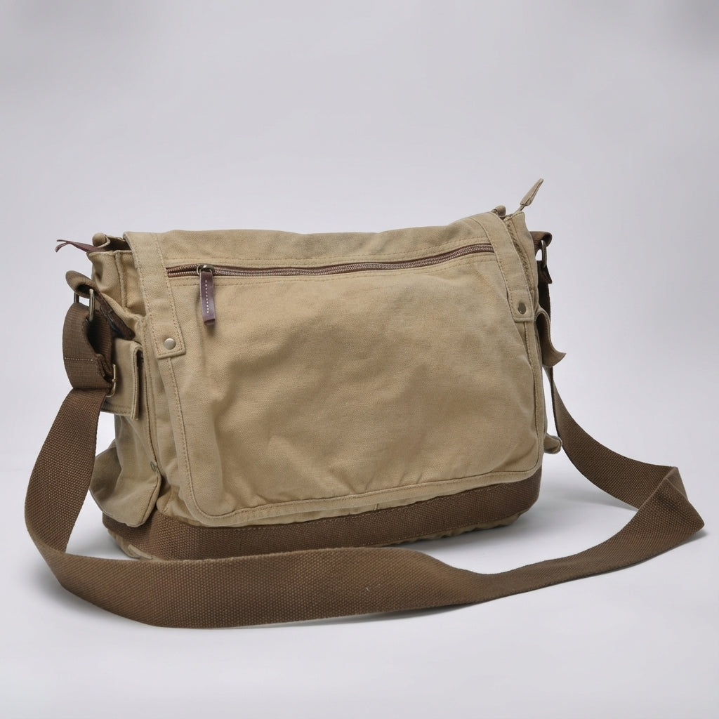 Öppen vintage canvas messengerväska visar organiserad insida med fack för laptop och tillbehör.