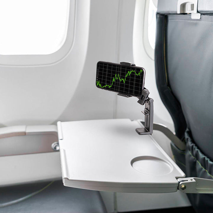 "Universell 360° telefonhållare, kompakt, svart design, monterad på flygplansbricka för resenärer och äventyr."