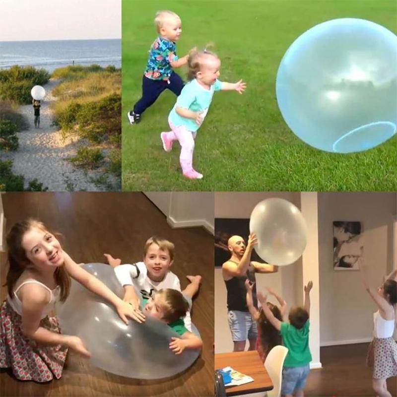 Familj som har roligt med en uppblåsbar bubbelboll i grön parkmiljö