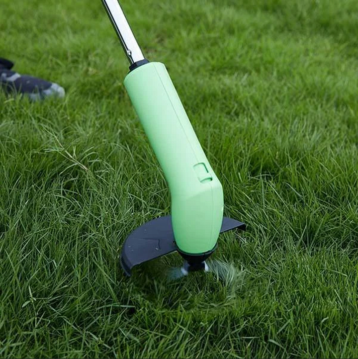 Minigrästrimmer med teleskopskaft som klipper gräs i trädgården