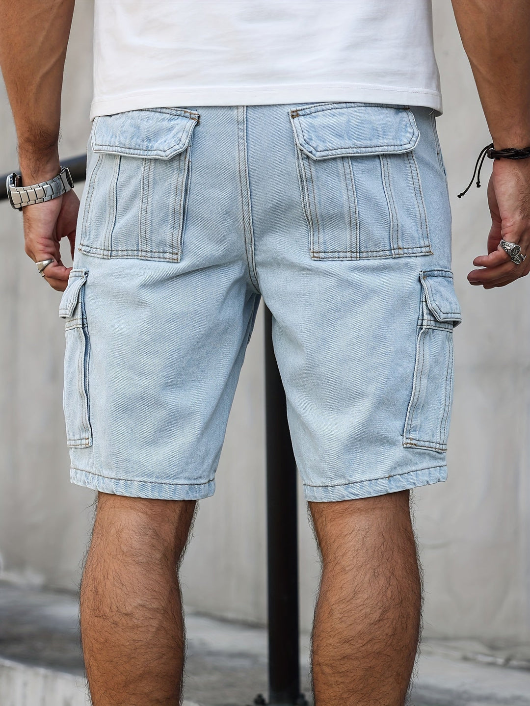 Sittande man i fritidsshorts av denim. Avslappnade herrshorts för optimal komfort och sommarbruk.