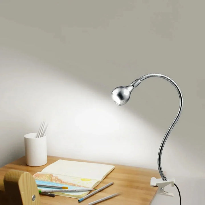 Silverfärgad USB-driven LED-läslampa med flexibel arm på ett skrivbord