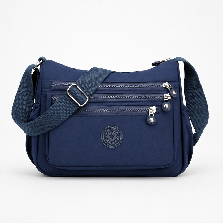 Modell som bär den svarta crossbody-väskan över axeln i stadsmiljö