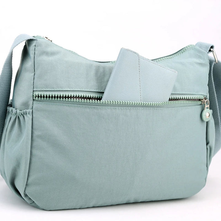 Framifrån: Vattentät dam messenger bag, minimalistisk design och funktionell för vardagen.