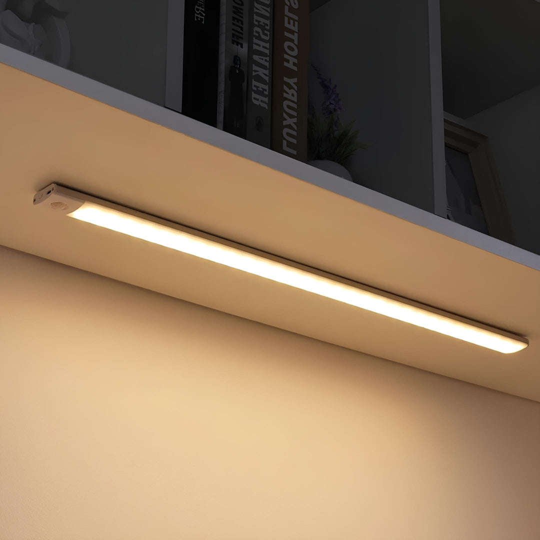 LED-skåpbelysning med rörelsesensor monterad under en hylla med varmt ljus