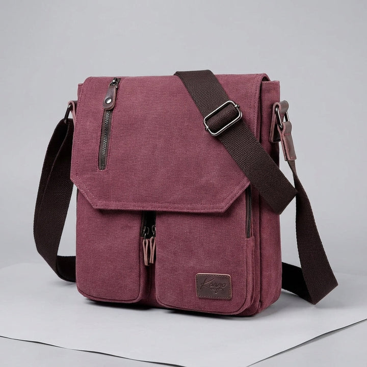 Öppen vintage messenger-väska med organiseringsfickor. Kompakt canvasväska för säker förvaring av prylar.