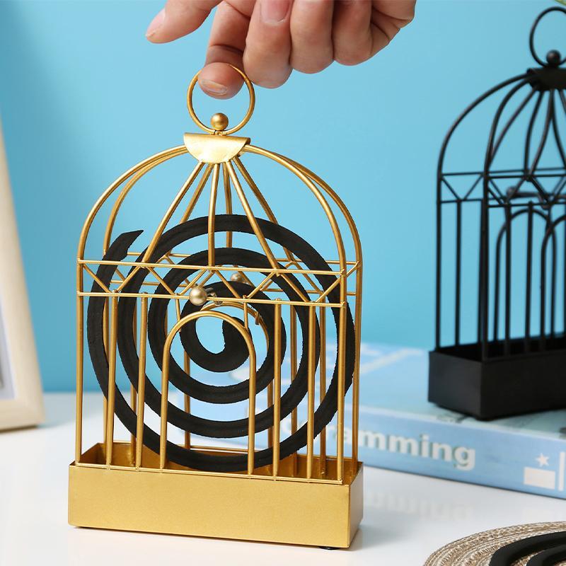"Vintage myggspolehållare i smidesjärn, fågelbur design, elegant heminredning i gyllene och svart nyans."