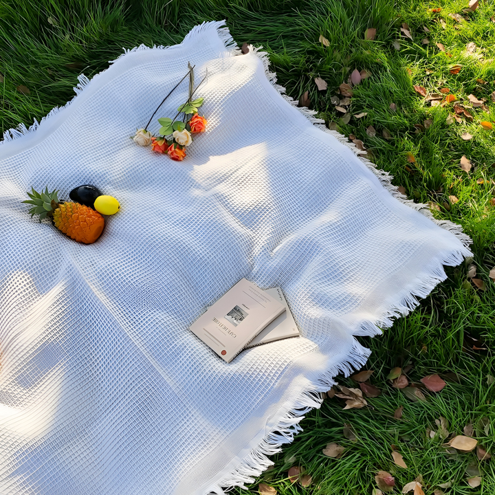 Vit boho picknickfilt med tofsar för mysiga utomhusaktiviteter. Mjuk och slitstark utomhusfilt.