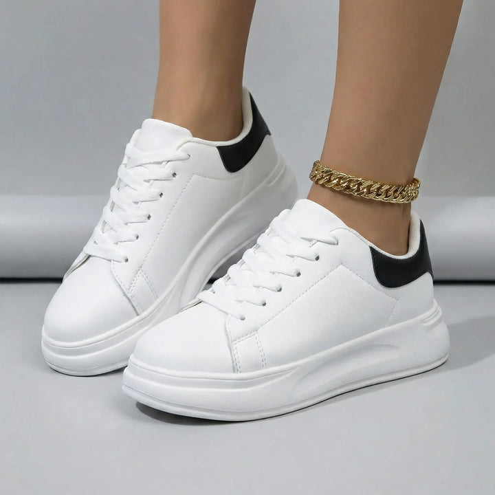 Vit Scarlett damsneaker. Stilfull och bekväm vardagssko. En lågsko med snörning för en avslappnad fritidsstil.