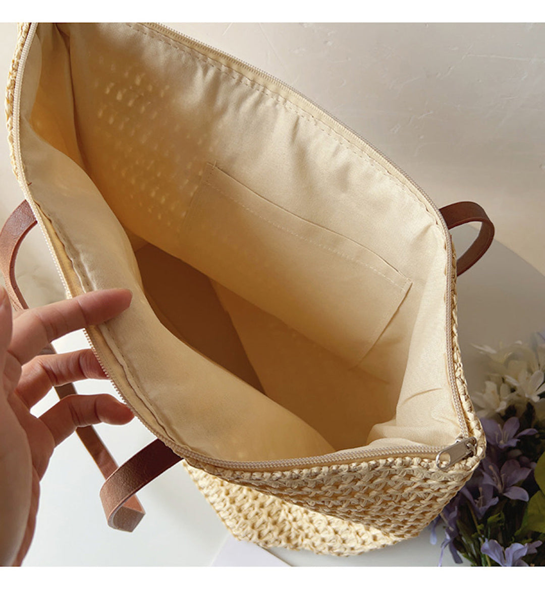 Vit korgväska med bruna detaljer och starka handtag. En praktisk unisex accessoar för soliga äventyr.