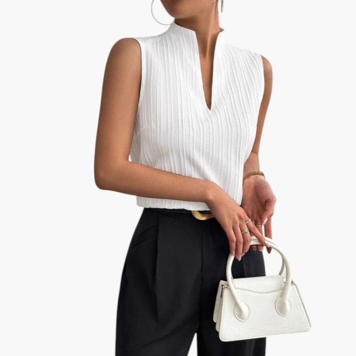 Bekväm vit damtopp, ärmlös med veckad design, hög krage. En modern blus för sommar, vardag och fest.
