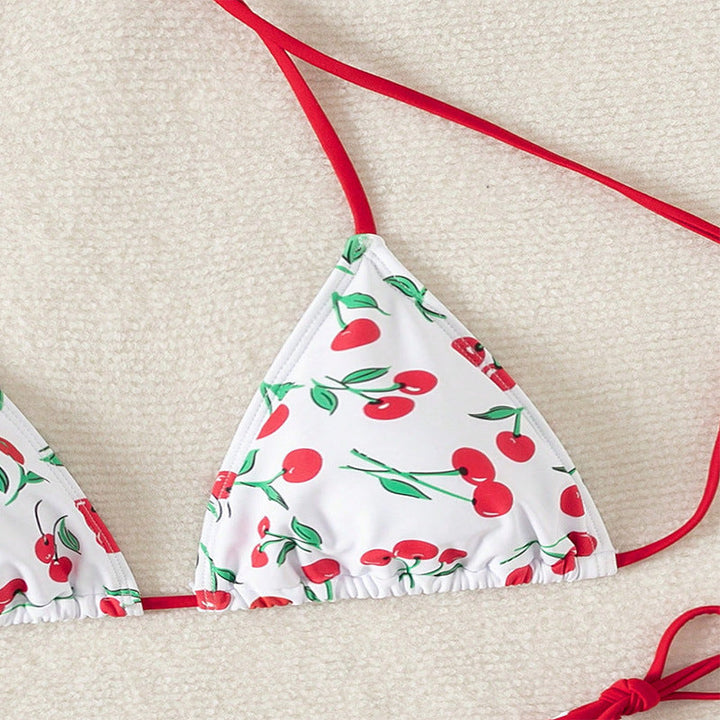Rosa triangelbikini med mörkröda körsbär, knytband. Moderiktiga badkläder för damer.