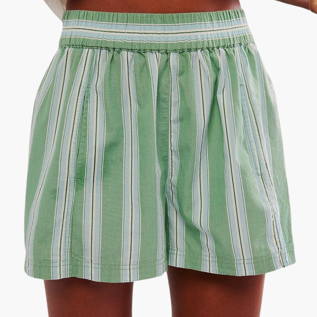 Kvinna bär bekväma dambyxor med vida ben och elastisk midja. Idealisk för sommarens casual stil.