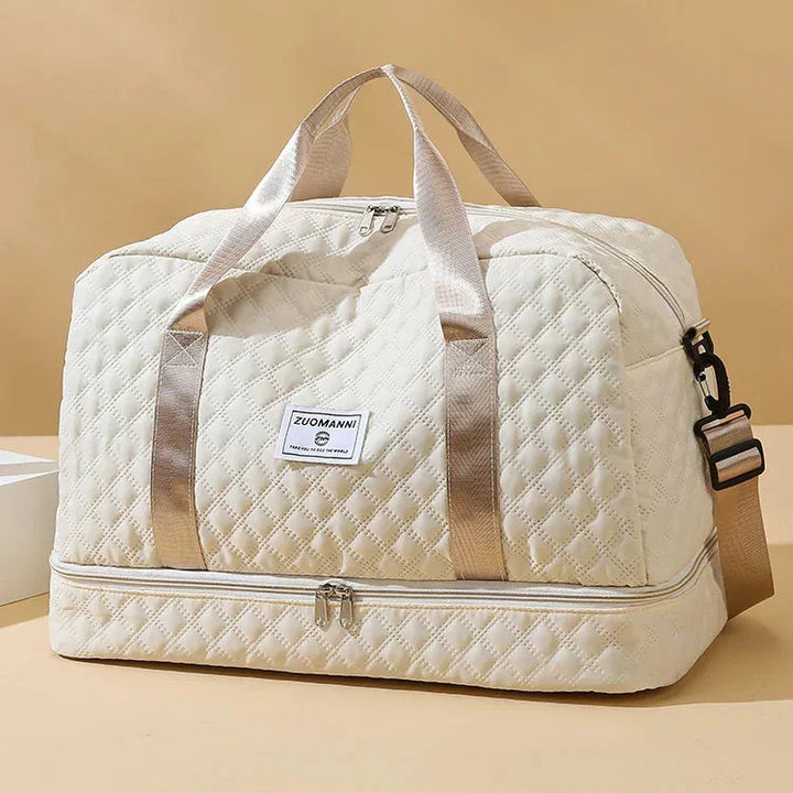Beige quiltad weekendväska med guldaktiga handtag och separat skofack