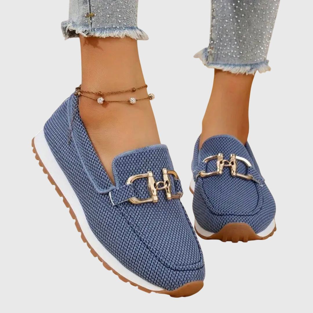Blå stickade loafers med platåsula och guldfärgat spänne på damfot