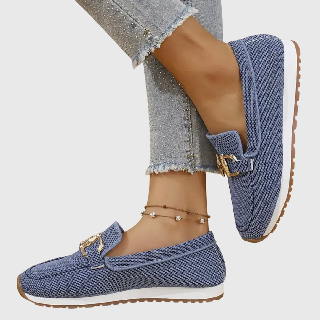 Sida av blå stickade loafers med platåsula och jeans