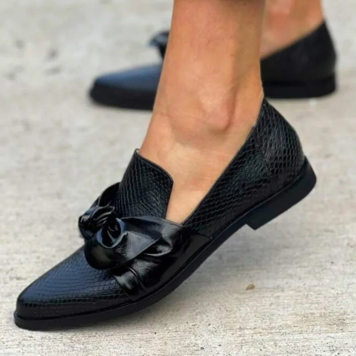 Sida av svart dam loafer i elegant modell med rosett