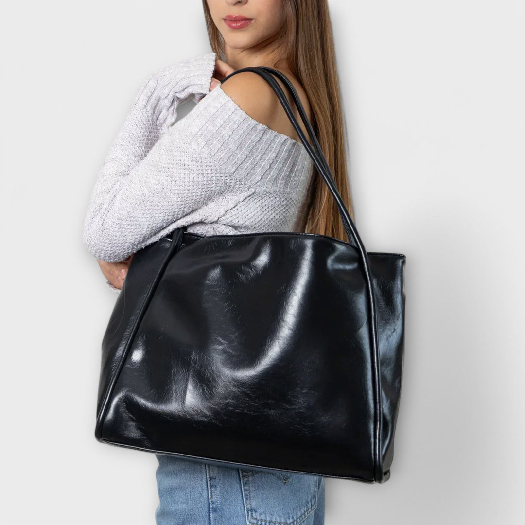 Kvinna som bär den svarta Olivia tote-väskan över axeln