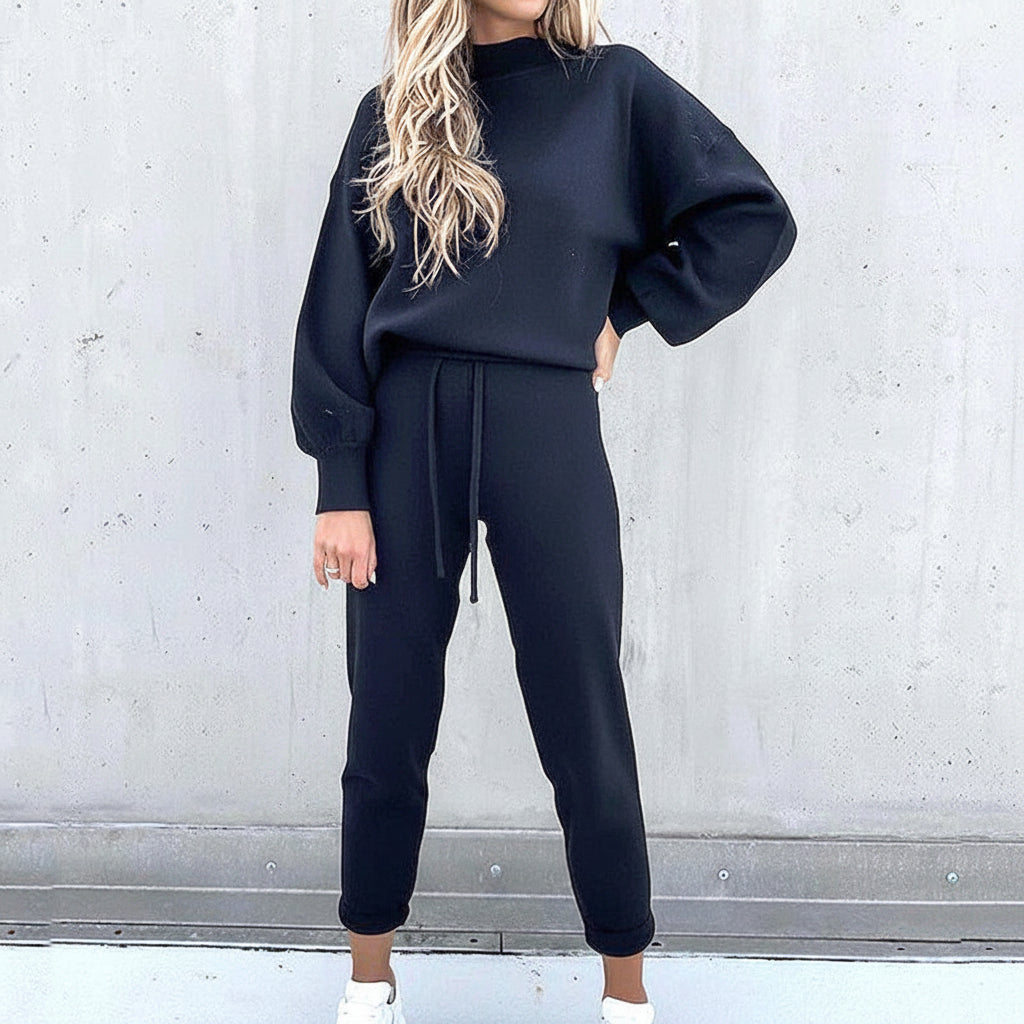 Dam i mörkblått mock-neck sweatshirt och jogger set