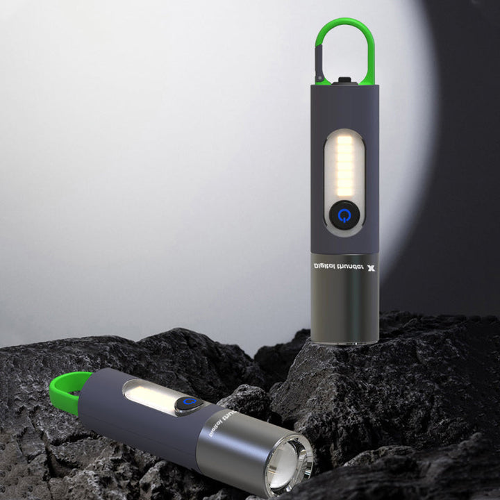 "Zoombar LED-ficklampa, kompakt design i silver, USB-C-laddning, fyra ljuslägen för utomhusäventyr, IP55-skydd."